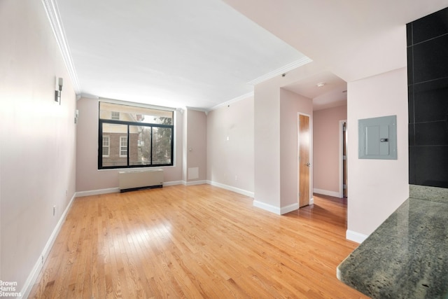 unfurnished room with crown molding, wood-type flooring, radiator, and electric panel