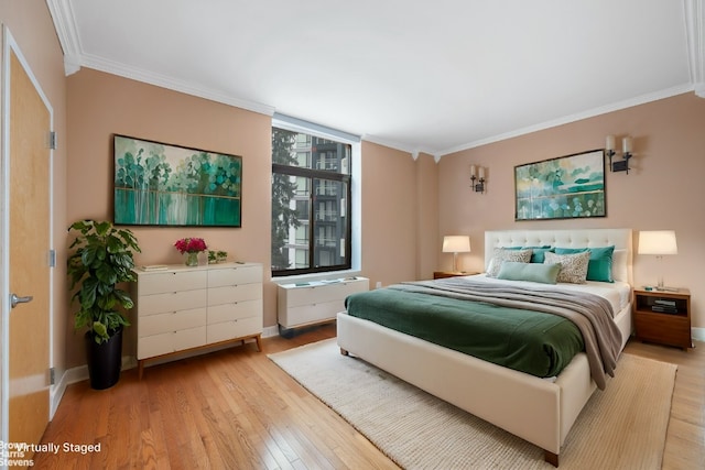 bedroom featuring multiple windows, crown molding, and light hardwood / wood-style flooring