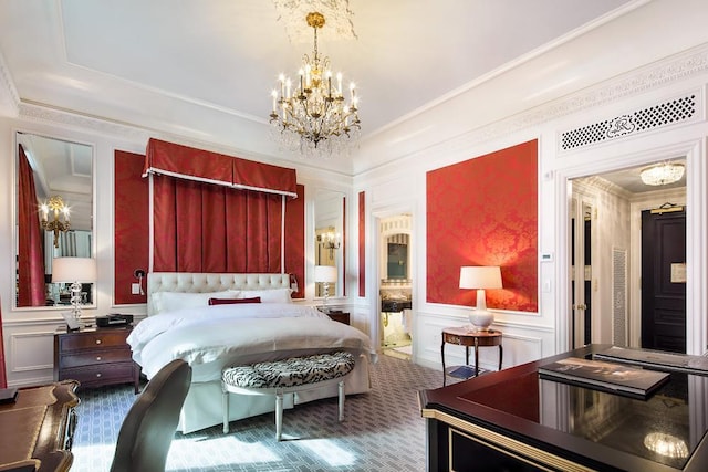 carpeted bedroom featuring a wainscoted wall, ornamental molding, an inviting chandelier, and a decorative wall