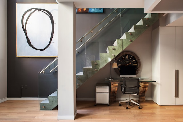 stairway featuring wood finished floors and baseboards