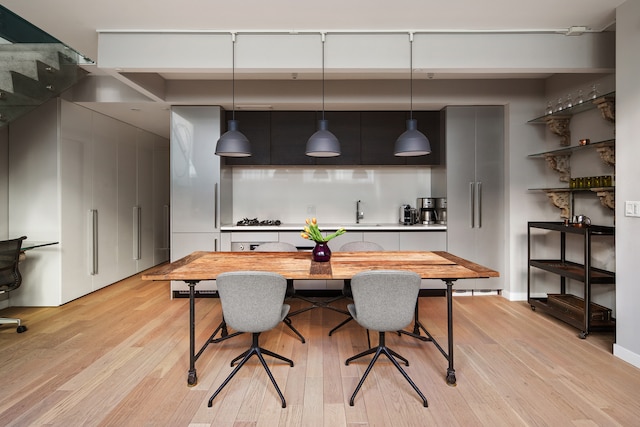 dining space featuring baseboards and light wood-style floors