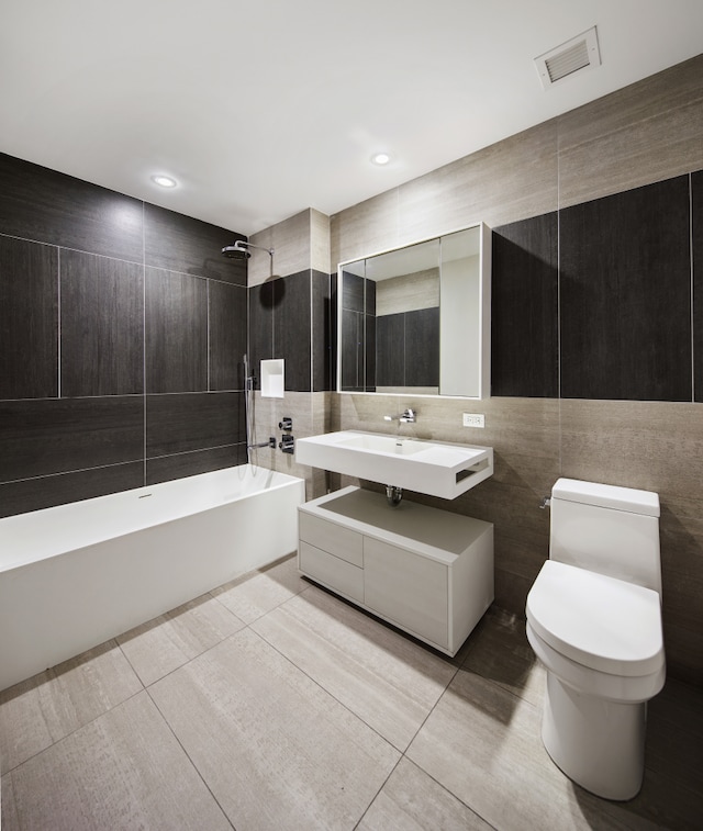 bathroom with visible vents, tile patterned floors, a sink, bathtub / shower combination, and tile walls