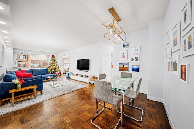 dining space featuring a chandelier and dark parquet floors