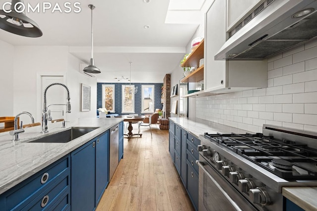 kitchen with sink, appliances with stainless steel finishes, tasteful backsplash, blue cabinets, and light wood-type flooring