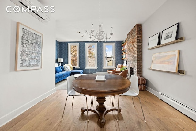 dining space with a baseboard radiator, a brick fireplace, an inviting chandelier, and light hardwood / wood-style floors