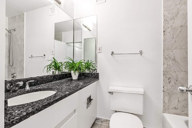 full bathroom with vanity, tiled shower / bath, and toilet