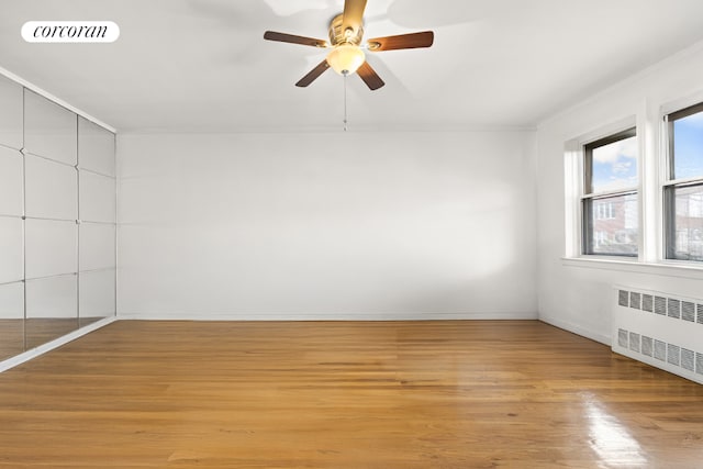 spare room featuring light hardwood / wood-style flooring, radiator heating unit, ornamental molding, and ceiling fan