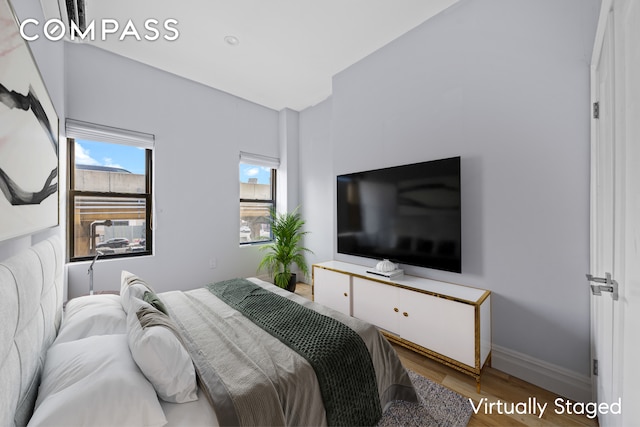 bedroom with baseboards and wood finished floors