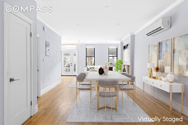 dining space with a wall unit AC, baseboards, french doors, crown molding, and light wood-type flooring