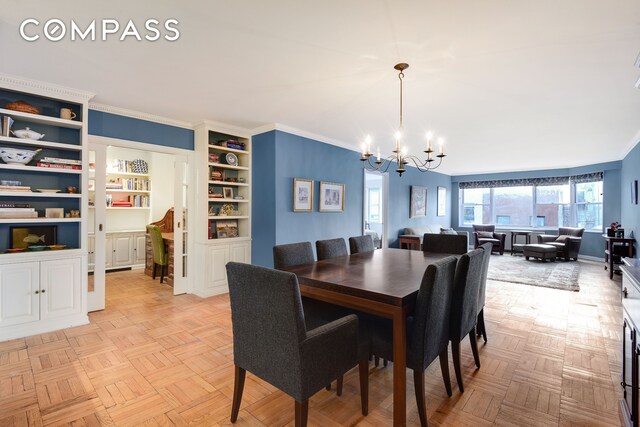 dining area featuring an inviting chandelier, crown molding, built in shelves, and light parquet floors