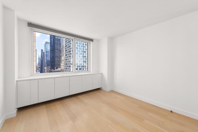 unfurnished room with light wood-type flooring