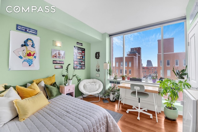 bedroom featuring a city view and wood finished floors