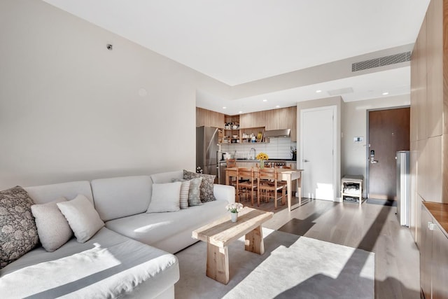 living room featuring sink and light hardwood / wood-style floors