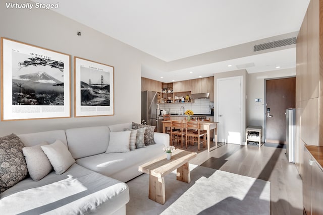 living room with sink and light hardwood / wood-style flooring