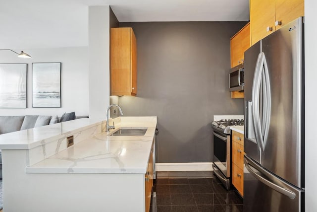 kitchen with light stone counters, sink, kitchen peninsula, and appliances with stainless steel finishes