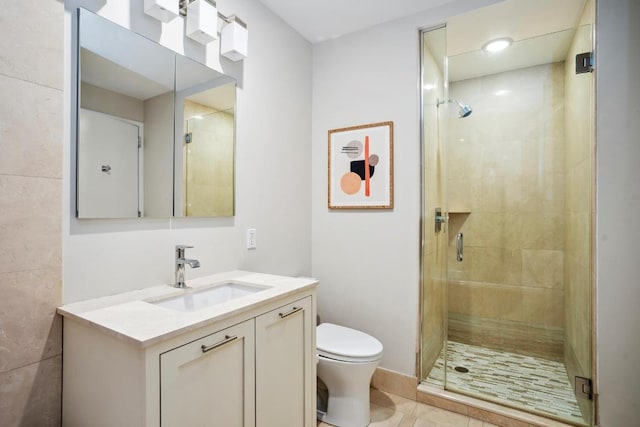 bathroom with tile patterned floors, vanity, toilet, and a shower with shower door