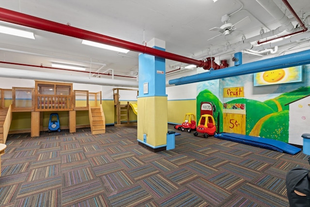 rec room with carpet and ceiling fan