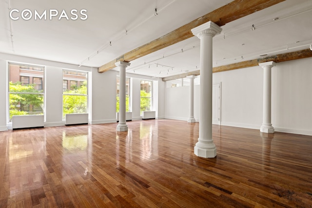 285 Lafayette St Unit 2B, New York City, NY 10012 - unfurnished living room with ornate columns, wood finished floors, and track lighting