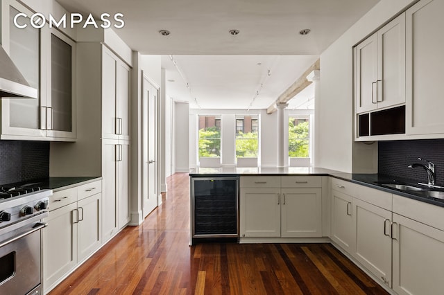 285 Lafayette St Unit 2B, New York City, NY 10012 - kitchen with beverage cooler, high end stainless steel range oven, a sink, a peninsula, and wall chimney range hood