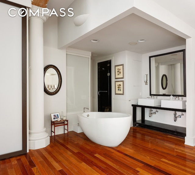 285 Lafayette St Unit 2B, New York City, NY 10012 - full bath featuring hardwood / wood-style flooring, a freestanding tub, double vanity, ornate columns, and recessed lighting