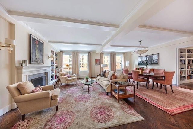 living room with built in features, baseboards, ornamental molding, a fireplace, and beam ceiling