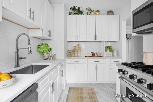 kitchen with white cabinetry, appliances with stainless steel finishes, sink, and backsplash