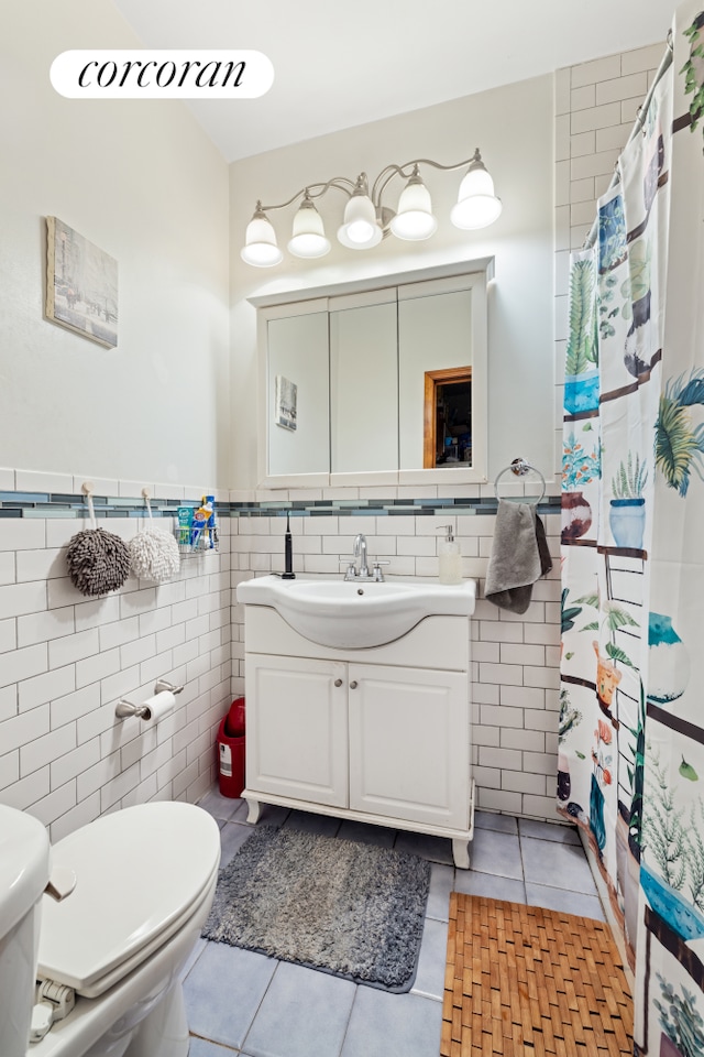 bathroom featuring toilet, vanity, tile walls, and tile patterned floors