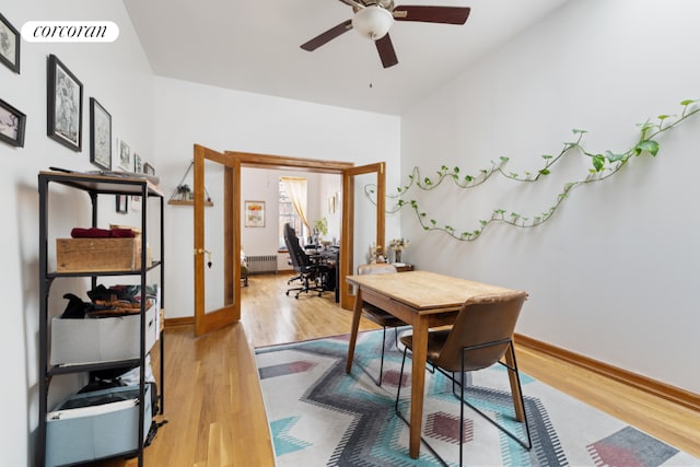 home office featuring french doors, ceiling fan, radiator, and light hardwood / wood-style floors