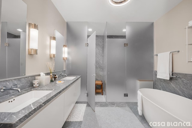 bathroom featuring double vanity, a stall shower, a freestanding bath, and a sink