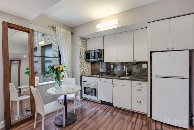 kitchen featuring plenty of natural light, white appliances, white cabinetry, and a sink