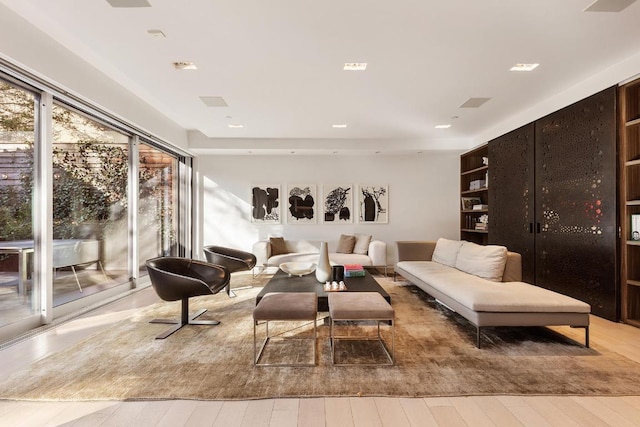 living area with built in features and light wood-style flooring