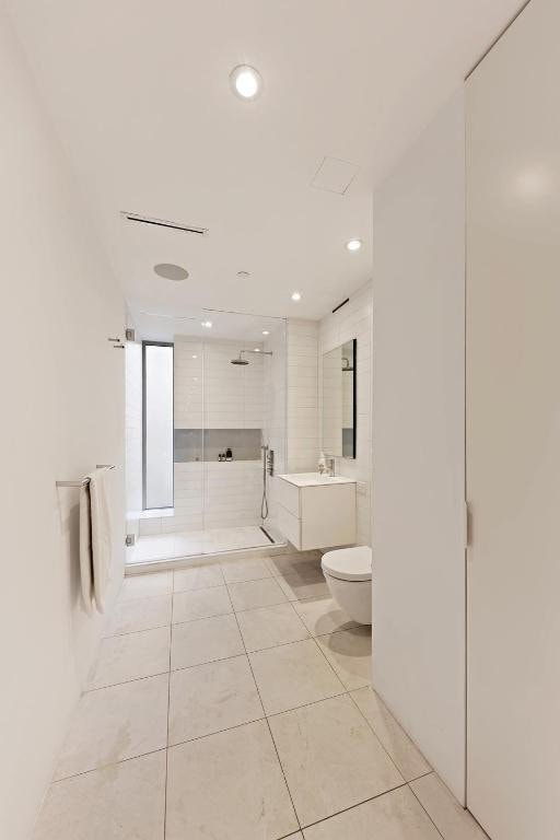 bathroom with vanity, tile patterned flooring, a shower with door, and toilet