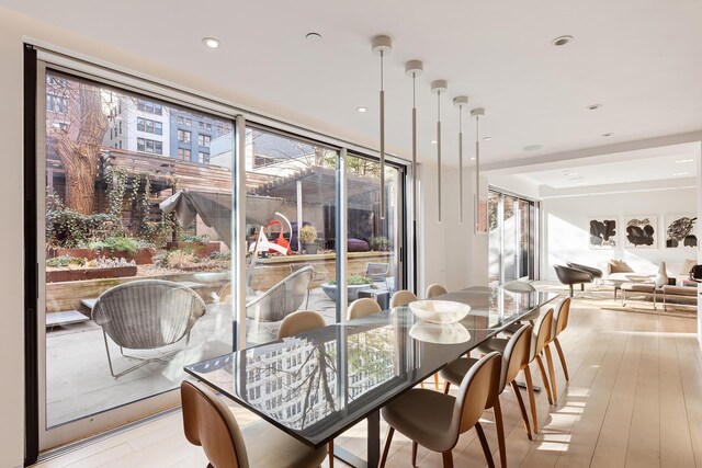 dining room featuring floor to ceiling windows and light wood-type flooring