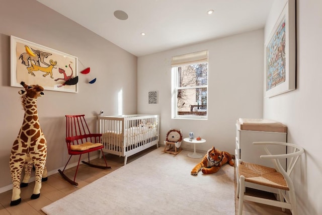 bedroom with a crib and light wood-type flooring