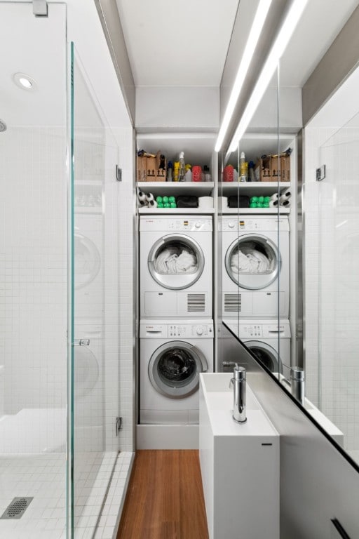 laundry room with dark hardwood / wood-style flooring and stacked washer and dryer