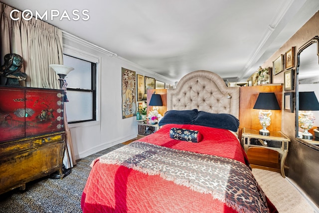 bedroom featuring crown molding and baseboards