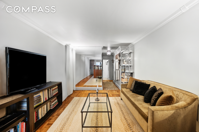 living area featuring wood finished floors and crown molding