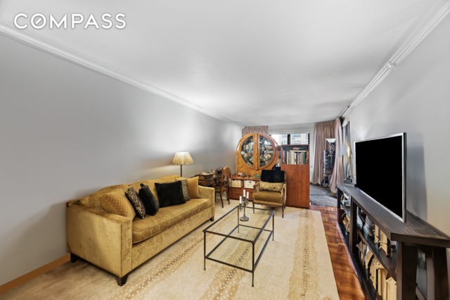living room with crown molding, wood finished floors, and baseboards
