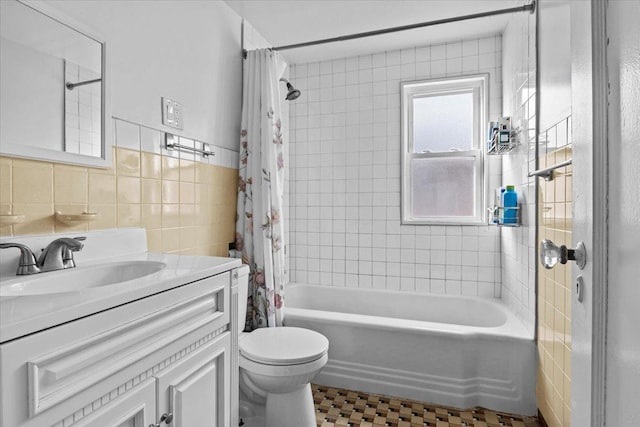 bathroom with shower / bath combo with shower curtain, tile walls, toilet, and vanity