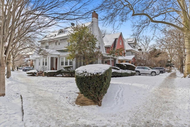 snow covered front of house with a chimney