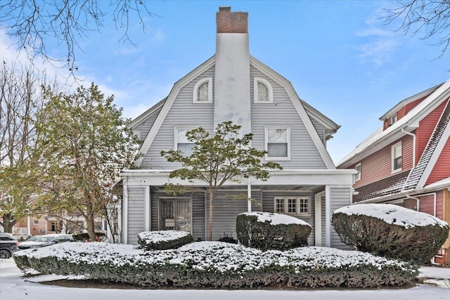 view of front of house featuring a chimney and a gambrel roof