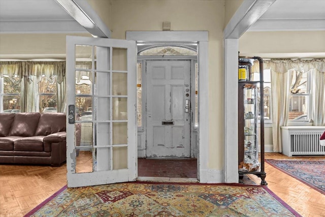 entryway with baseboards, radiator, and ornamental molding