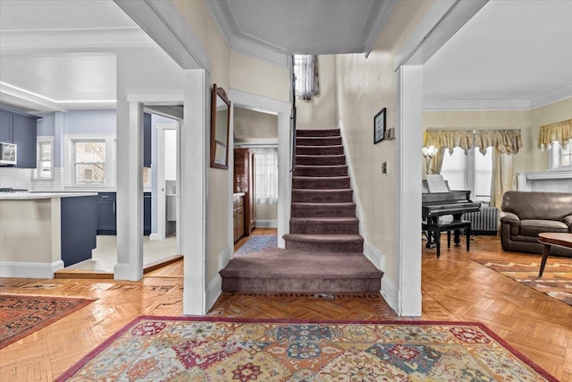 staircase with radiator, crown molding, and baseboards