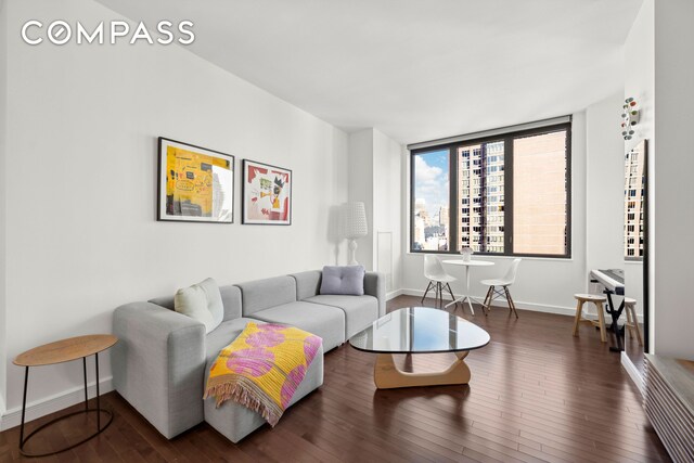 living room featuring hardwood / wood-style flooring and baseboards