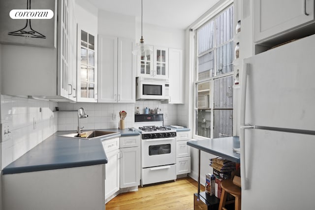 kitchen featuring sink, decorative light fixtures, white appliances, decorative backsplash, and white cabinets