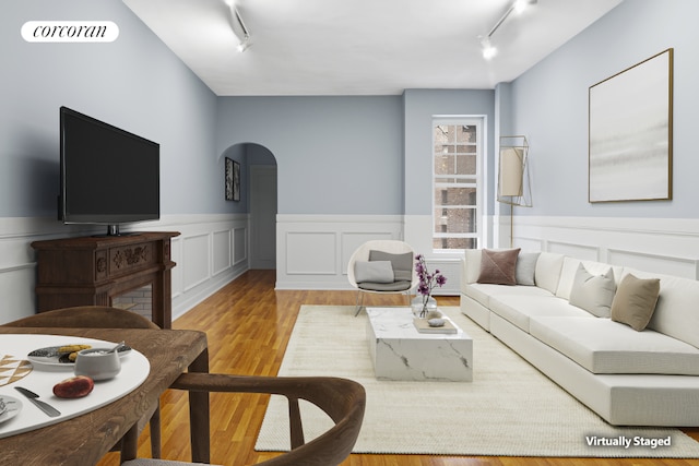 living room with rail lighting and light wood-type flooring