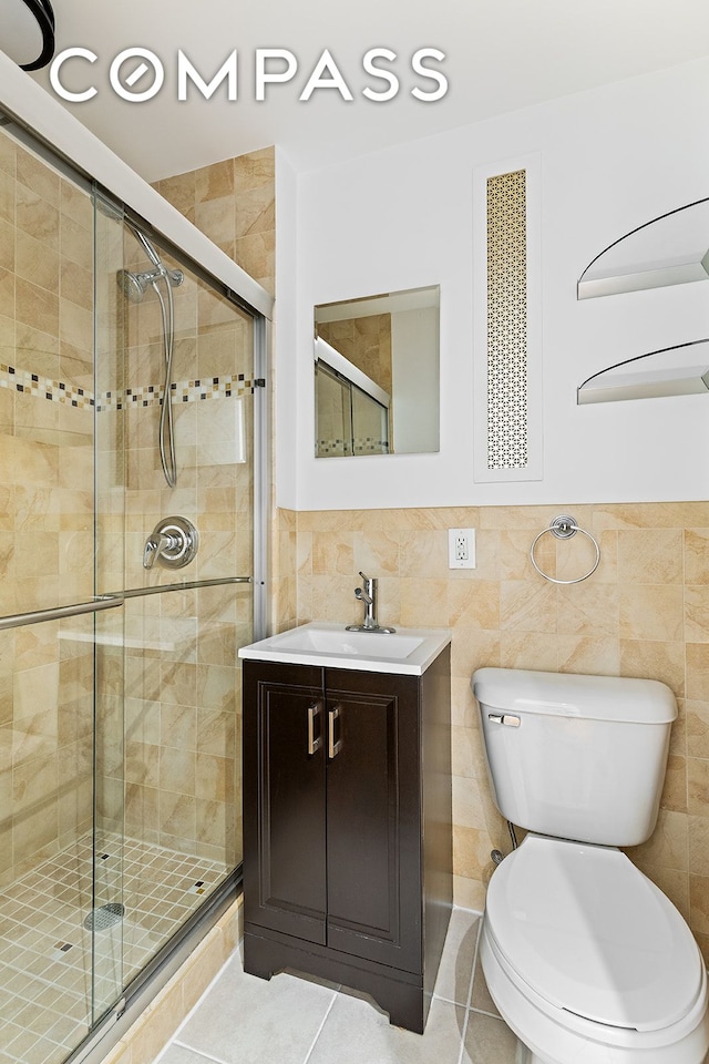 bathroom with toilet, a shower stall, tile walls, and tile patterned flooring