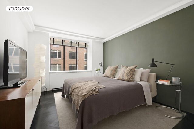 bedroom featuring crown molding and dark parquet flooring