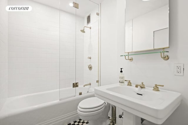 bathroom with shower / bath combination with glass door and toilet