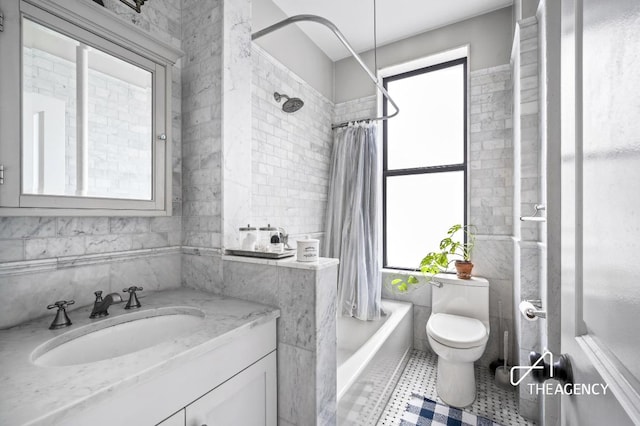 full bath with toilet, vanity, tile walls, and shower / bathtub combination with curtain